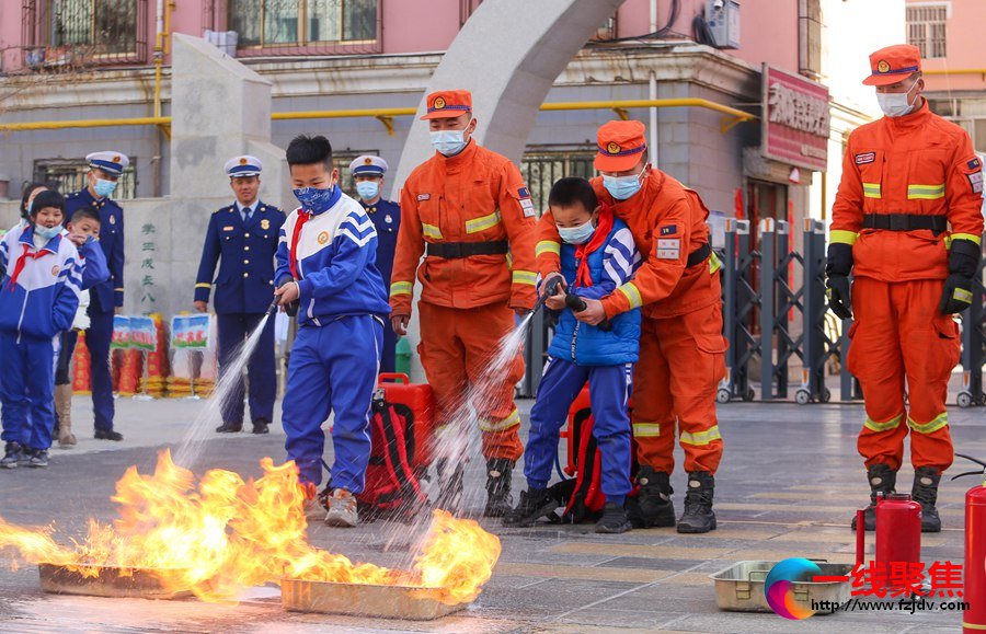 甘肃省森林消防总队张掖市支队消防员正在指导师生体验常规灭火装备。陈文彪摄